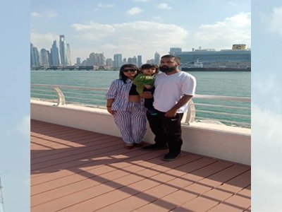Three people standing on a deck with a city skyline in the background